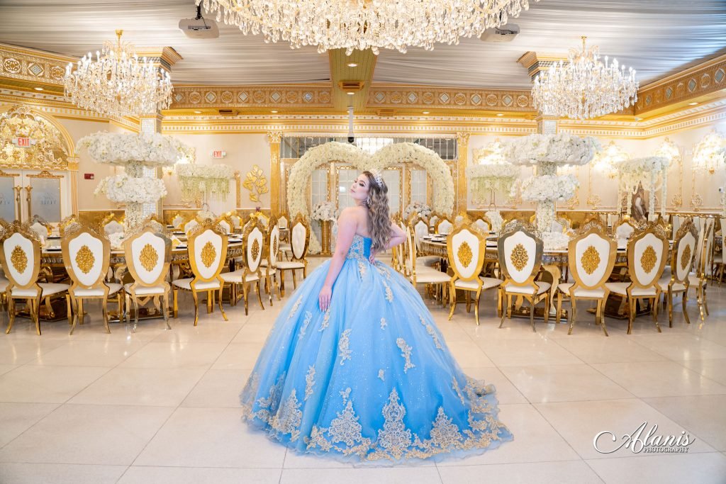 Quinceañera in a blue gown under crystal chandeliers in the Golden Palace ballroom